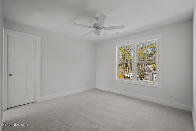 carpeted spare room with ceiling fan