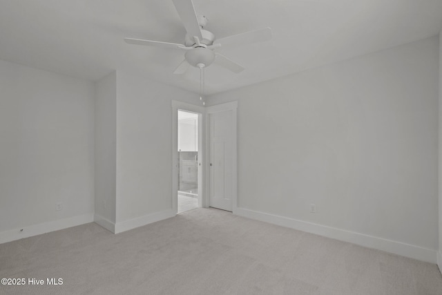 spare room with ceiling fan and light colored carpet