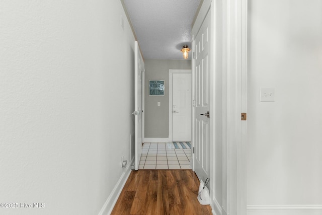 hallway with wood-type flooring and a textured ceiling