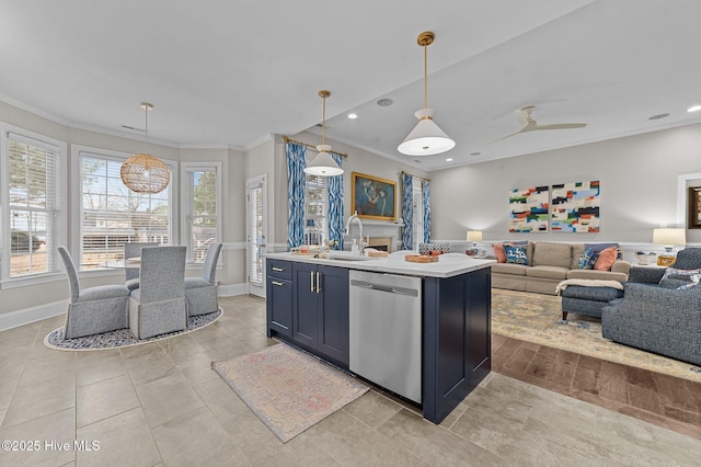 kitchen with a center island with sink, pendant lighting, sink, and stainless steel dishwasher