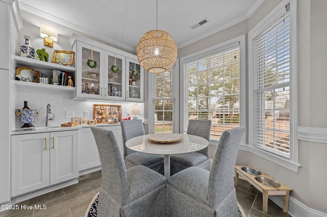 dining space with sink and ornamental molding