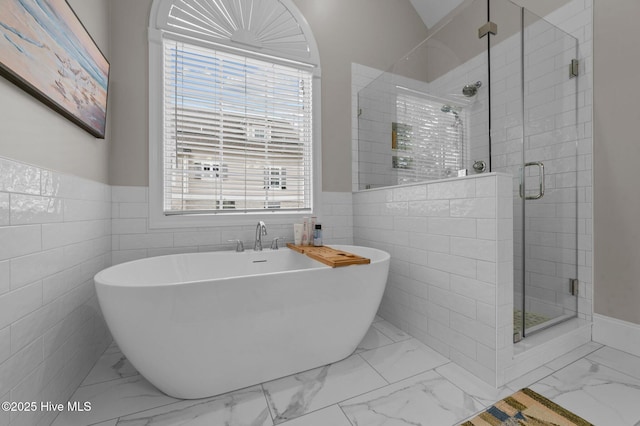 bathroom with tile walls and independent shower and bath