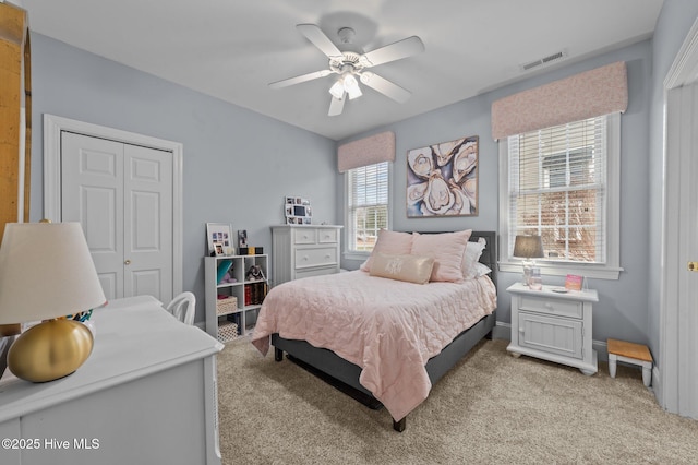 bedroom featuring ceiling fan, light colored carpet, and a closet