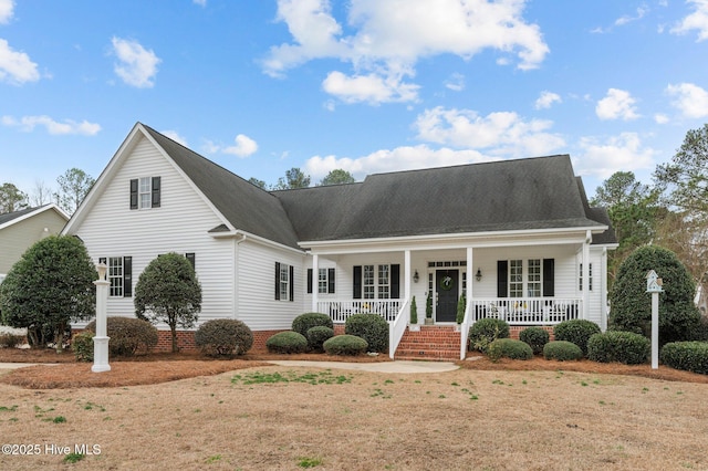 cape cod home featuring covered porch and a front lawn