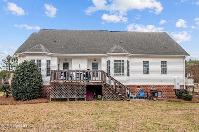 back of property with a wooden deck and a yard