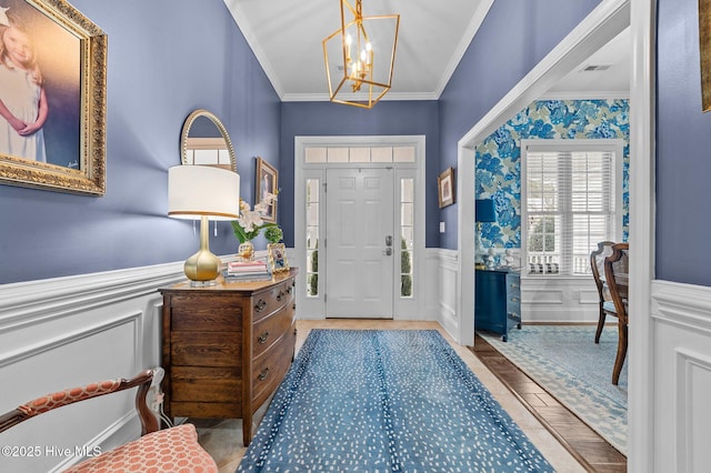 foyer entrance featuring an inviting chandelier and ornamental molding