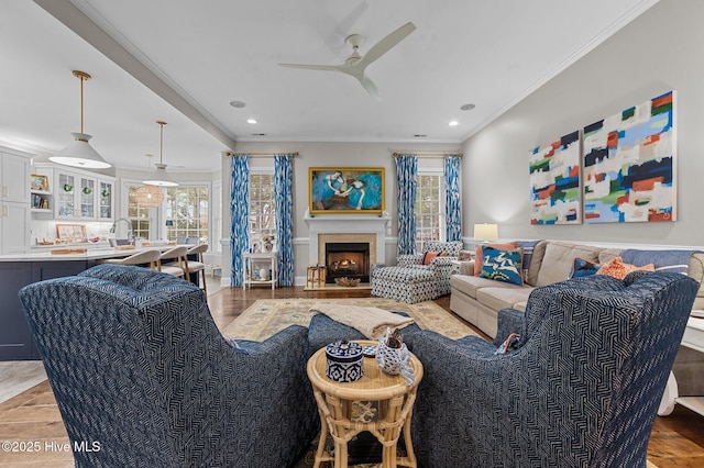 living room with crown molding, ceiling fan, and hardwood / wood-style flooring