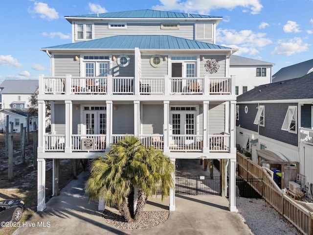 rear view of property featuring covered porch, a carport, a balcony, and french doors