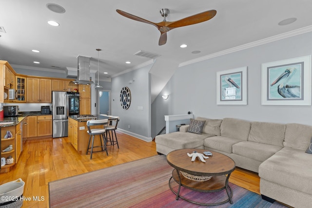 living room with crown molding, ceiling fan, and light wood-type flooring