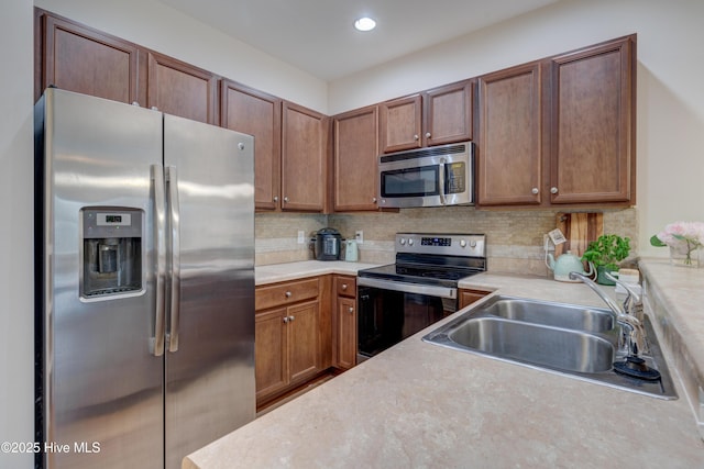 kitchen with tasteful backsplash, sink, and appliances with stainless steel finishes