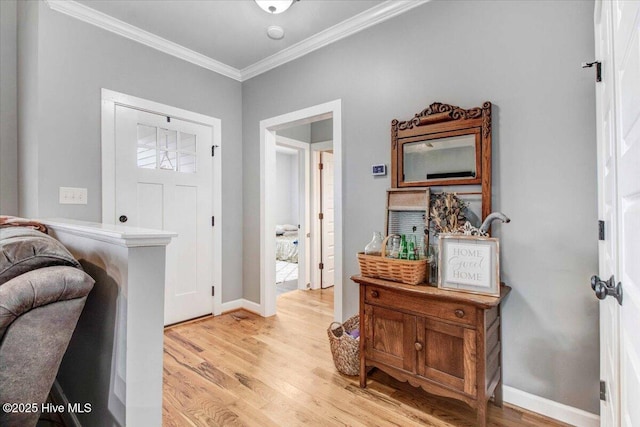 entryway with crown molding and light hardwood / wood-style floors