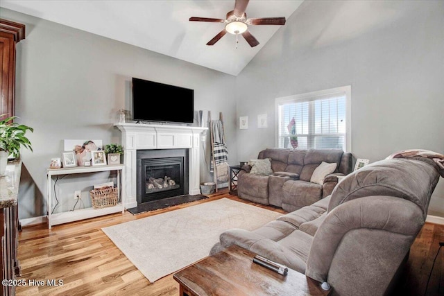 living room featuring high vaulted ceiling, ceiling fan, and light wood-type flooring