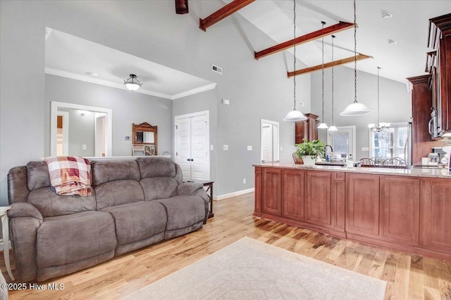 living room featuring a notable chandelier, crown molding, beamed ceiling, and light wood-type flooring