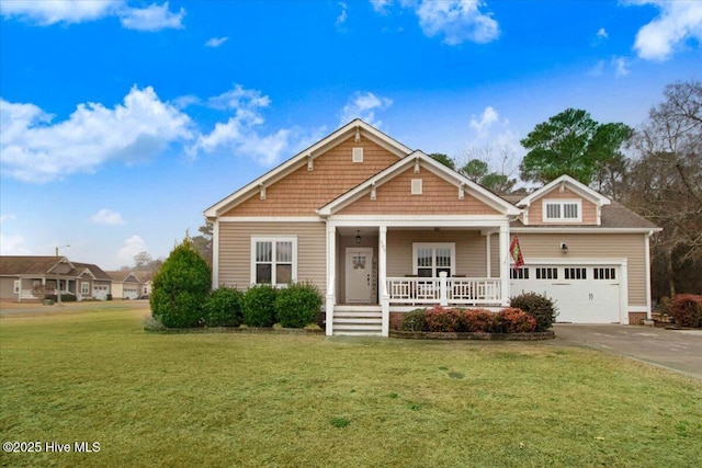 view of front of home featuring a porch, a garage, and a front lawn