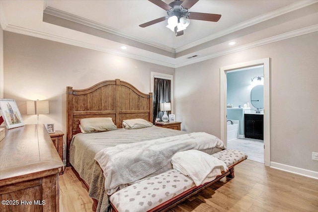 bedroom featuring ornamental molding, light hardwood / wood-style flooring, and a tray ceiling