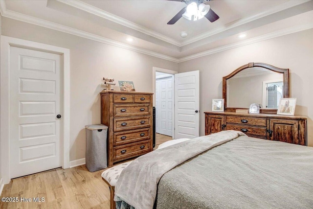 bedroom featuring ceiling fan, ornamental molding, a raised ceiling, and light hardwood / wood-style flooring