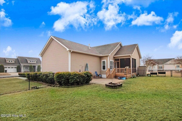 rear view of house with a deck, a yard, an outdoor fire pit, a sunroom, and a patio area