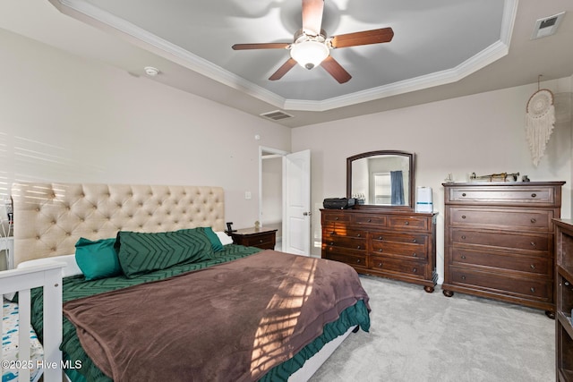 carpeted bedroom with a tray ceiling, ornamental molding, and ceiling fan