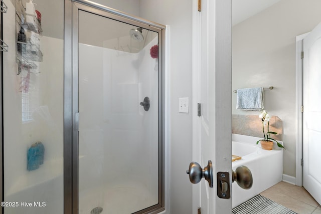 bathroom with tile patterned floors and shower with separate bathtub