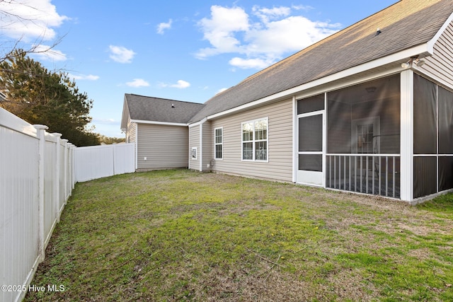 back of property featuring a yard and a sunroom