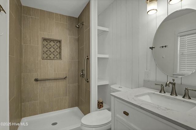 bathroom with vanity, toilet, and tiled shower