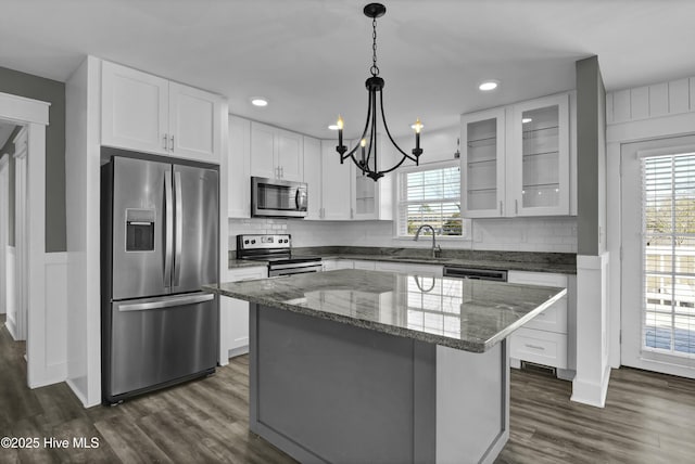 kitchen featuring white cabinetry, appliances with stainless steel finishes, a center island, and dark wood-type flooring