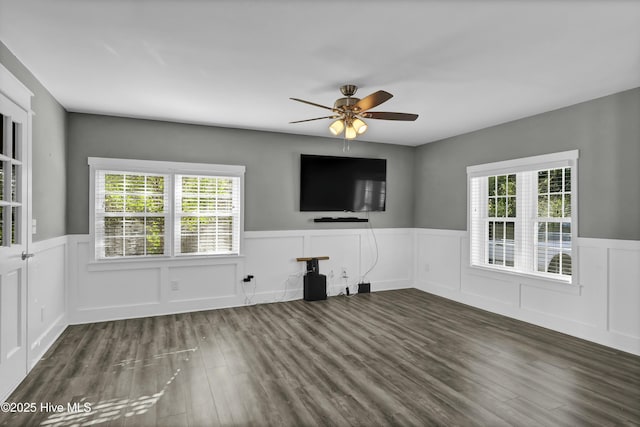 unfurnished living room featuring ceiling fan and dark hardwood / wood-style flooring