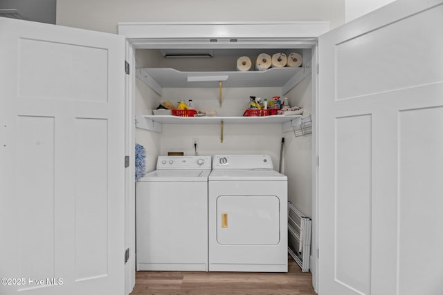 laundry area featuring separate washer and dryer and light hardwood / wood-style floors