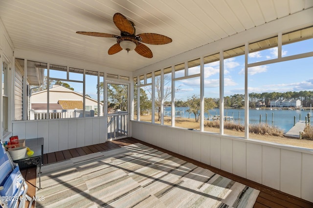 unfurnished sunroom with plenty of natural light, ceiling fan, and a water view