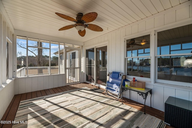 unfurnished sunroom featuring wood ceiling and ceiling fan