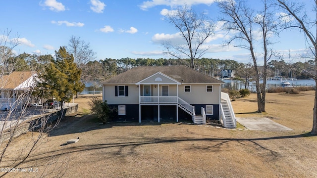 view of front of property with a porch, a water view, and a front yard