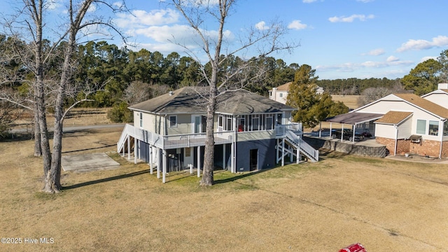 back of property featuring a carport, a sunroom, and a yard