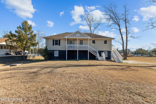 rear view of property featuring a yard and covered porch