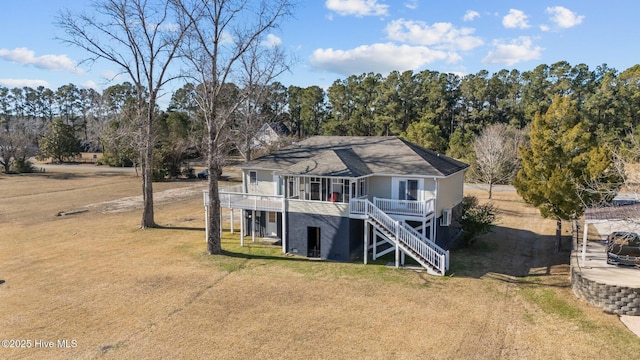 rear view of property featuring a yard and a deck