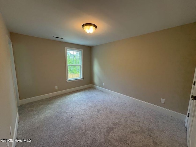 spare room featuring baseboards, carpet flooring, and visible vents