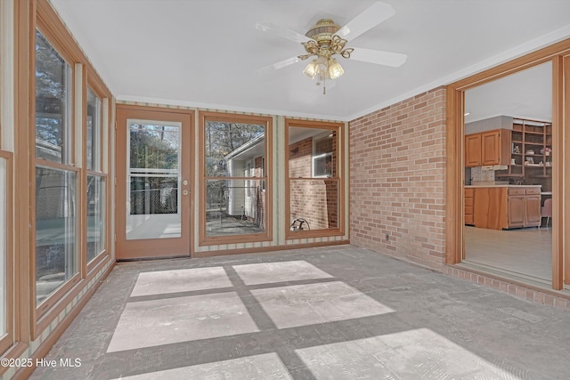 unfurnished sunroom featuring ceiling fan