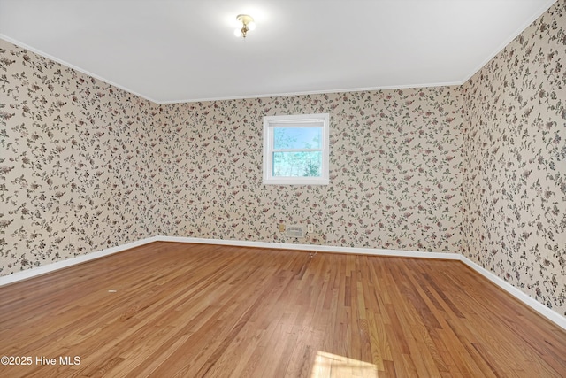 empty room with hardwood / wood-style flooring and ornamental molding