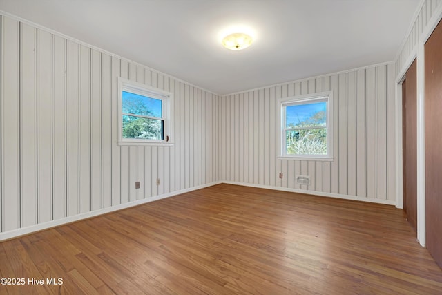 empty room with hardwood / wood-style floors and a wealth of natural light