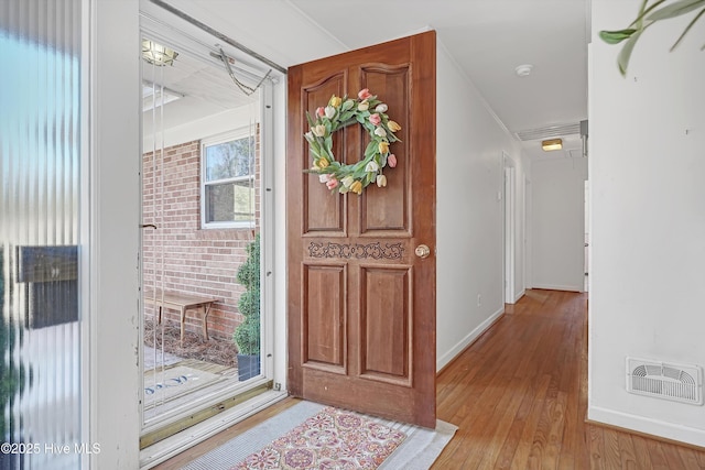 entryway featuring crown molding and light wood-type flooring