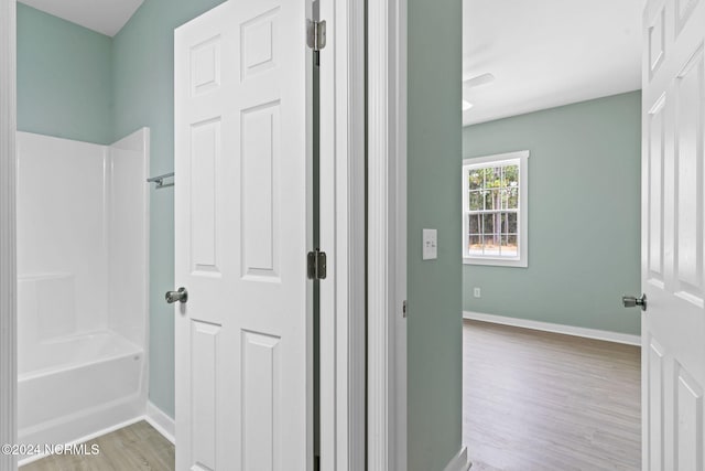 bathroom with hardwood / wood-style floors and shower / bathing tub combination