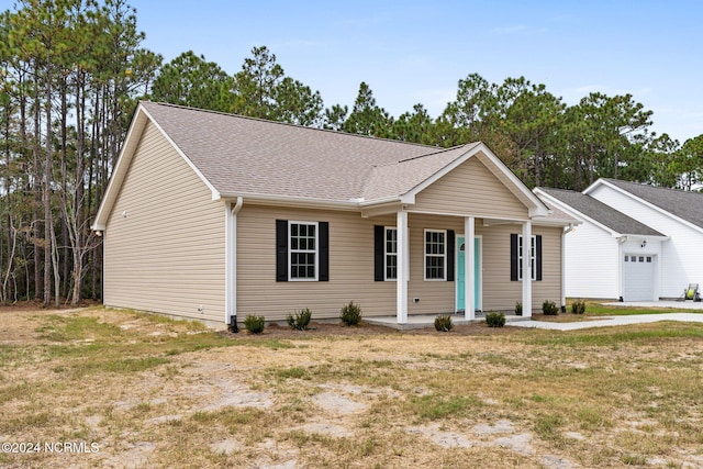 ranch-style house with a garage, covered porch, and a front lawn