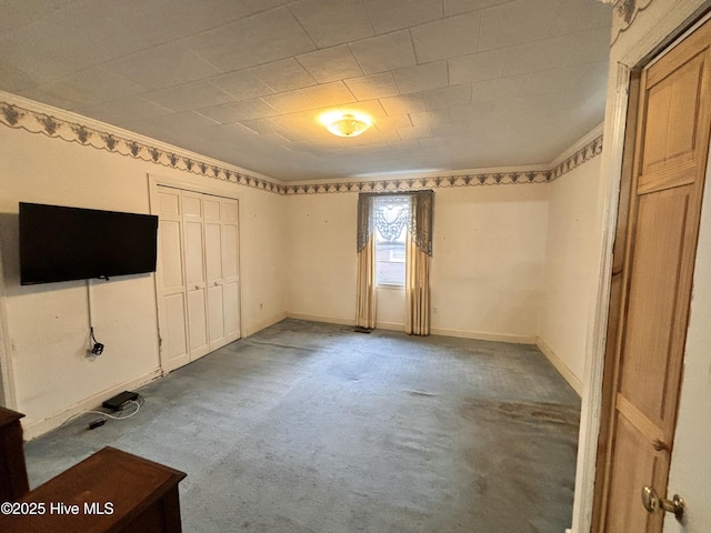 unfurnished bedroom featuring a closet, crown molding, and baseboards