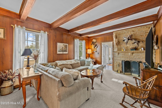 carpeted living room featuring beamed ceiling, plenty of natural light, a fireplace, and wood walls