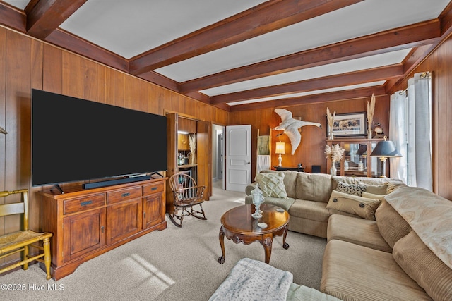 carpeted living room with beam ceiling and wood walls