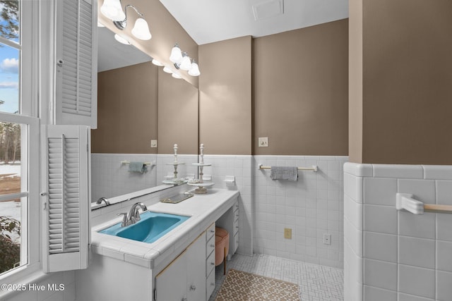 bathroom with tile patterned floors, vanity, and tile walls