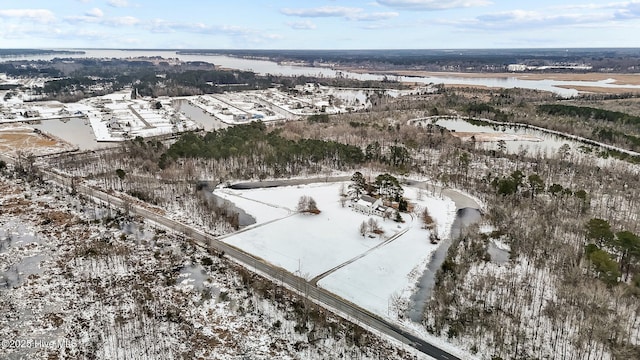 snowy aerial view with a water view