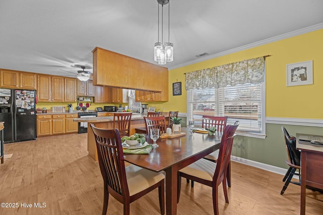 dining room featuring crown molding, light hardwood / wood-style flooring, and ceiling fan with notable chandelier