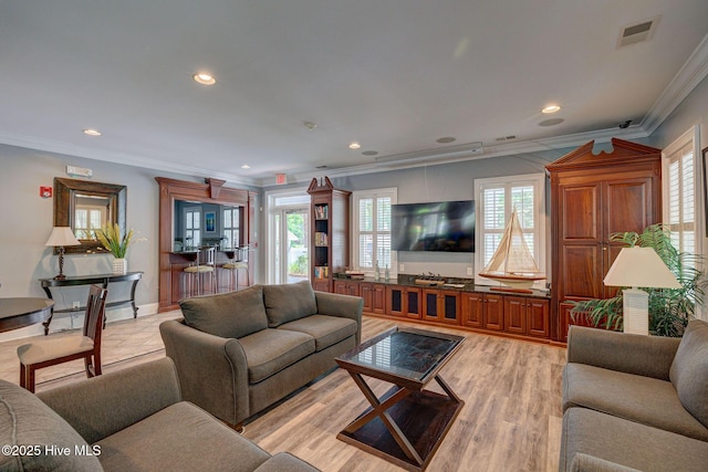 living room with ornamental molding, a healthy amount of sunlight, and light hardwood / wood-style floors