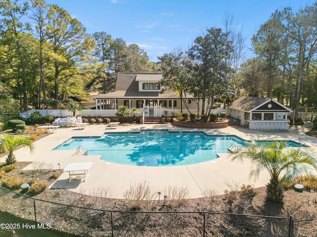 view of swimming pool featuring a diving board and a patio