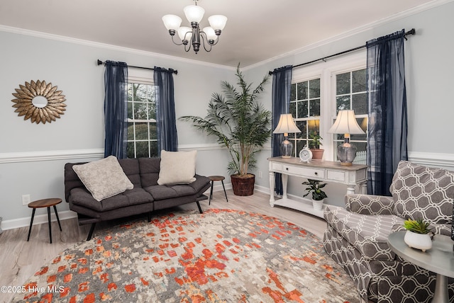 sitting room with an inviting chandelier, ornamental molding, and light wood-type flooring